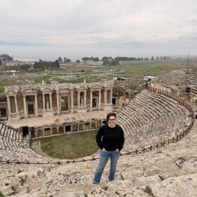 Me standing in the Roman Theatre of Hierapolis at Pamukkale with a glimpse of the white terrace pools in the background